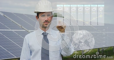 A futuristic engineer-expert in solar photovoltaic panels, uses a hologram with remote control, performs complex actions to monito Stock Photo