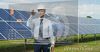 A futuristic engineer-expert in solar photovoltaic panels, uses a hologram with remote control, performs complex actions to monito Stock Photo