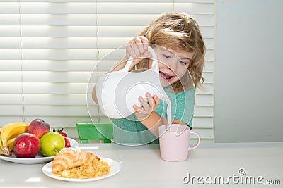 Fuuny little boy pouring whole cows milk for breakfast. Child boy eating organic healthy food. Healthy vegetables with Stock Photo