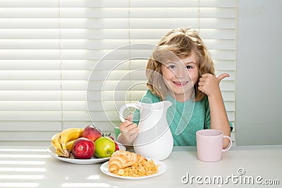 Fuuny little boy pouring whole cows milk for breakfast. Schoolkid eating breakfast before school. Portrait of child sit Stock Photo