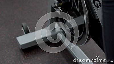 Füße junger Dame, die ein Training auf stationärem Fahrrad in der modernen Turnhalle hat, Abschluss oben stock footage Füße junger Dame, die ein Training auf stationärem Fahrrad in der modernen Turnhalle hat, Abschluss oben stock footage