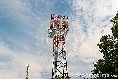 5G cell tower and separate single cellular provider mast Stock Photo