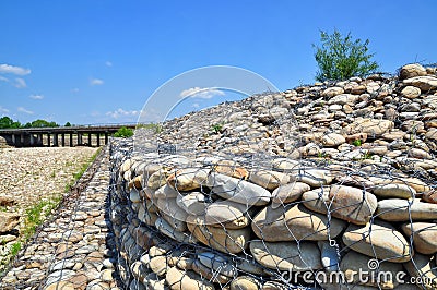 Gabion on the bank of the river Stock Photo