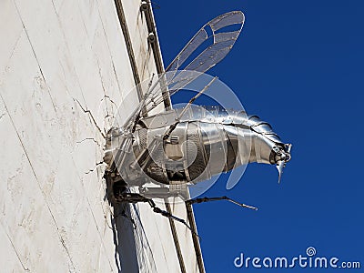 Metal bee crashed into the wall, humorous installation in the building of the museum of humor Editorial Stock Photo