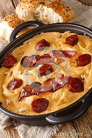 Gachas manchegas with bacon and chorizo Delicious simple Spanish food close-up in a pan. Vertical Stock Photo