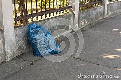 GalaÈ›i, Romania - September 14, 2022: Plastic trash bag on the sidewalk. Closed plastic bag with the logo of the company for Editorial Stock Photo