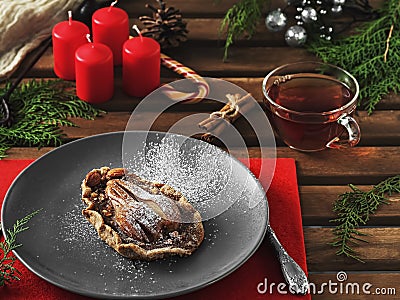 Galette homemade autumn pear cookies with cinnamon and creamy caramel on a ceramic plate. Thuja branches, candles, decorations for Stock Photo