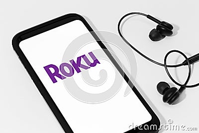 ROKU logo on Smart phone screen on white table Editorial Stock Photo