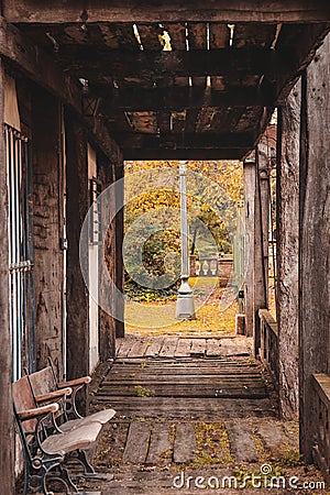 Gallery with wooden floor and ceiling, with wooden seats and garden in the background Stock Photo