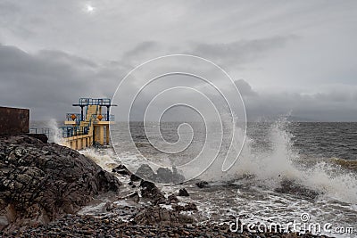 Galway - Ireland 02/28/2020: Blackrock public diving board hit by powerful waves before storm Jorge. Salthill Editorial Stock Photo
