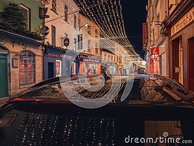 Galway, Ireland - 12.25.2022: Illuminated decoration reflection on a dark car roof. Celebrating Christmas concept. Beautiful town Editorial Stock Photo