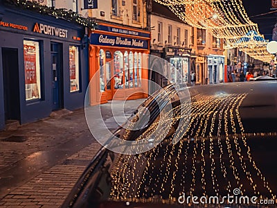 Galway, Ireland - 12.25.2022: Illuminated decoration reflection on a dark car roof. Celebrating Christmas concept. Beautiful town Editorial Stock Photo