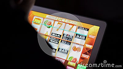 Gambling addicted man in front of online casino slot machine on laptop computer at nigh Stock Photo