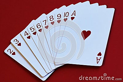 Allegorical way from simple to complex. Fan of cards of heart suit on red background as step by step instruction to achieve goal Stock Photo