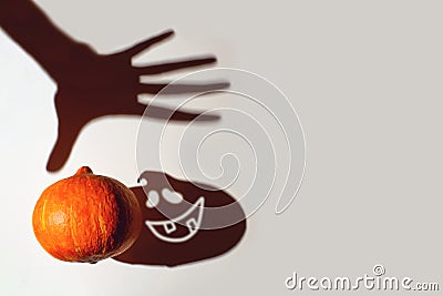 The game of shadows. The hand reaches for the pumpkin, she screams. Halloween concept Stock Photo