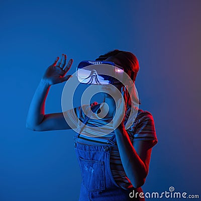 The game vr.The girl in the helmet and with the controller plays a game with creative light Stock Photo