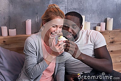 Gamer couple eating cupcakes in bedroom Stock Photo