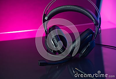 Gamer Headphones Dark Background and colorful pink Light. Stock Photo