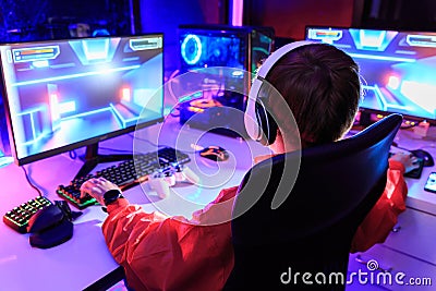Gamer playing online game on PC in dark room Stock Photo