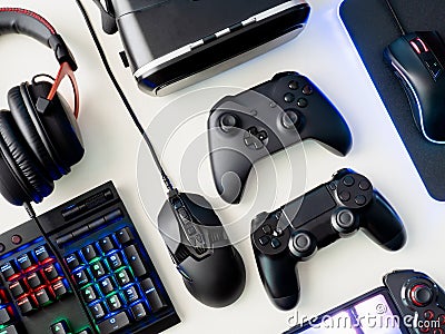 Gamer workspace concept, top view a gaming gear, mouse, keyboard, joystick, headset and mouse pad on white table background. Stock Photo