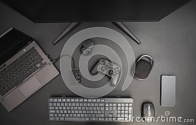 Gaming top view desk on dark background with joystick, computer, keyboard, mouse, smarpthone and speaker. Gaming as a job concept Stock Photo