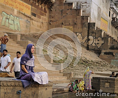 A woman is sitting quietly in the Ganges in the early morning. Editorial Stock Photo