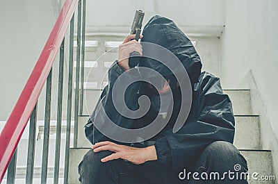 Gangster sitting on stairs, alone with his thoughts and his guns Stock Photo