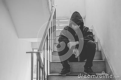 Gangster sitting on stairs, alone with his thoughts and his guns Stock Photo