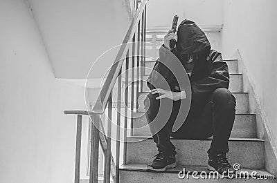 Gangster sitting on stairs, alone with his thoughts and his guns Stock Photo