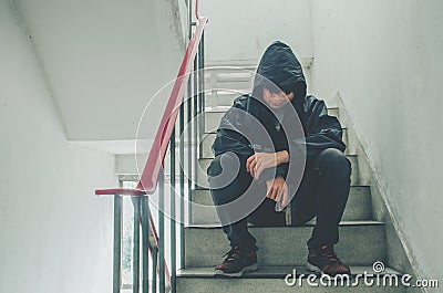Gangster sitting on stairs, alone with his thoughts and his guns Stock Photo