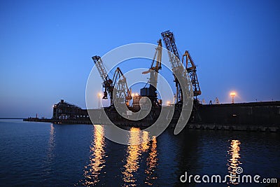 Ganrty cranes in the sea port on the coast of the Azov Sea at susnset Stock Photo