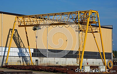 Gantry crane and its shadow on the factory wall. Stock Photo