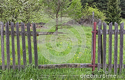 Gap in an old crumbling wooden fence Stock Photo