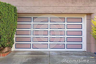 Garage door with white grid trims and pink panels with blue frames at San Francisco, California Stock Photo