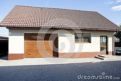 Garage garden house. Sliding gates. Hot sunny day. Stock Photo