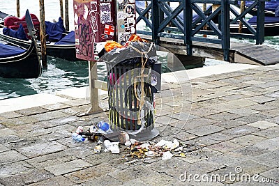 Garbage bin full of litter on the Grand Canal promenade in Venice, Italy . Stock Photo