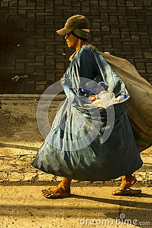 Garbage collector carrying two large bags. Editorial Stock Photo