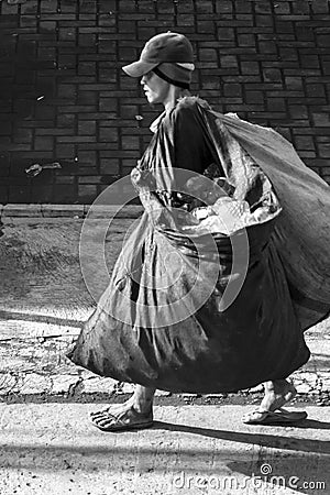 Garbage collector carrying two large bags. Editorial Stock Photo