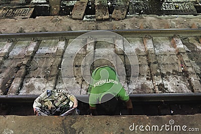 The garbage collector of the Indian Railways gathers the garbage from the railroad Editorial Stock Photo