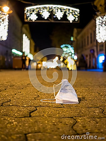 Garbage dropped under Christmas lights Stock Photo