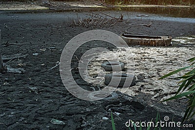 Garbage and old tires on the river Bank. Environmental contamination. Ecology concept Stock Photo