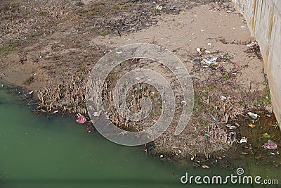 Garbage in the River. Environmental pollution. Plastic bottles, bags, trash in river. Rubbish and pollution floating in water. Editorial Stock Photo