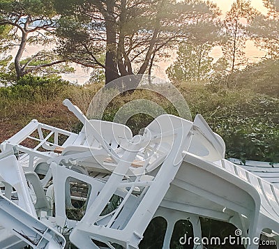 Garbage after vacationers at the resort. A pile of broken plastic sunbeds in the resort town. The problem of plastic recycling Stock Photo