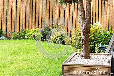 Garden Border with fencing shrubs grass and general garden decoration Stock Photo