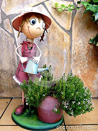 Garden decoration of a funny statue watering the plants Stock Photo