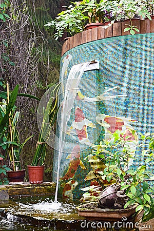 Garden fountain surrounded by plants. A cozy quiet place to relax in nature Stock Photo