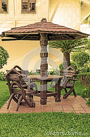 Garden furniture. chairs and table under wooden umbrella at garden Stock Photo
