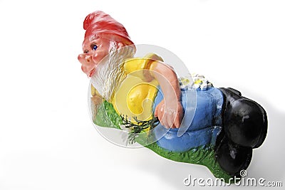 Garden gnome lying on meadow Stock Photo