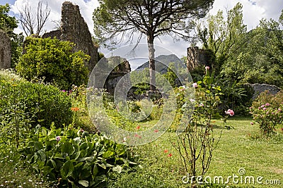 Garden of Ninfa in Italy with flowers, trees and ruins of the medieval city Ninfa. Editorial Stock Photo