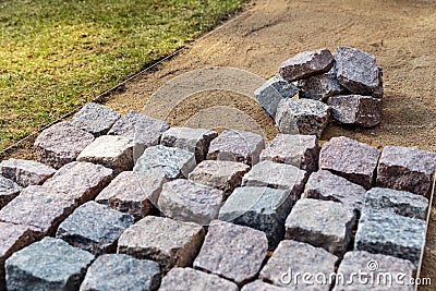 Garden path construction - laying granite stone pavers Stock Photo